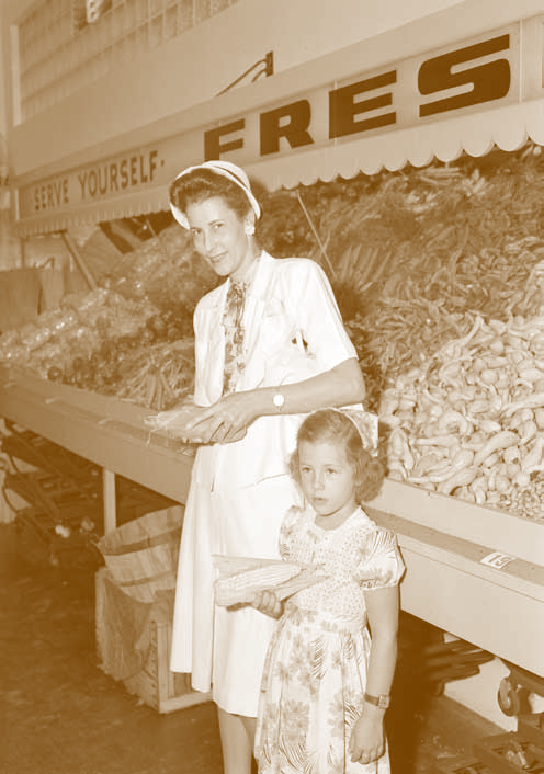 A mother and daughter shuck corn in the produce section at Winn-Dixie.