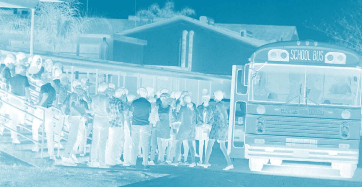 Students waiting in line to board a school bus