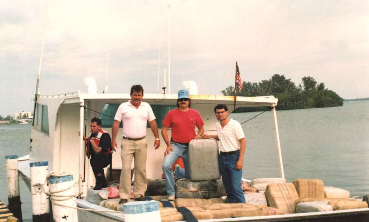 Special Agent David Waller (in the blue cap) stands between United States Coast Guard and Customs agents with a 2,000-pound marijuana seizure. The marijuana was brought into the Coast Guard station in Fort Myers. 