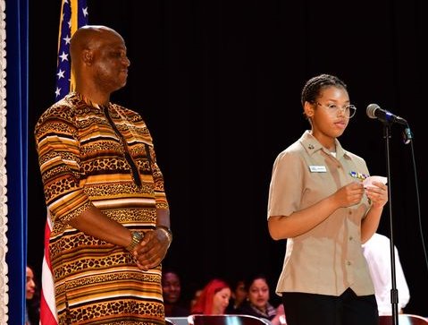 A member of the Naval JROTC introduces a new citizen.