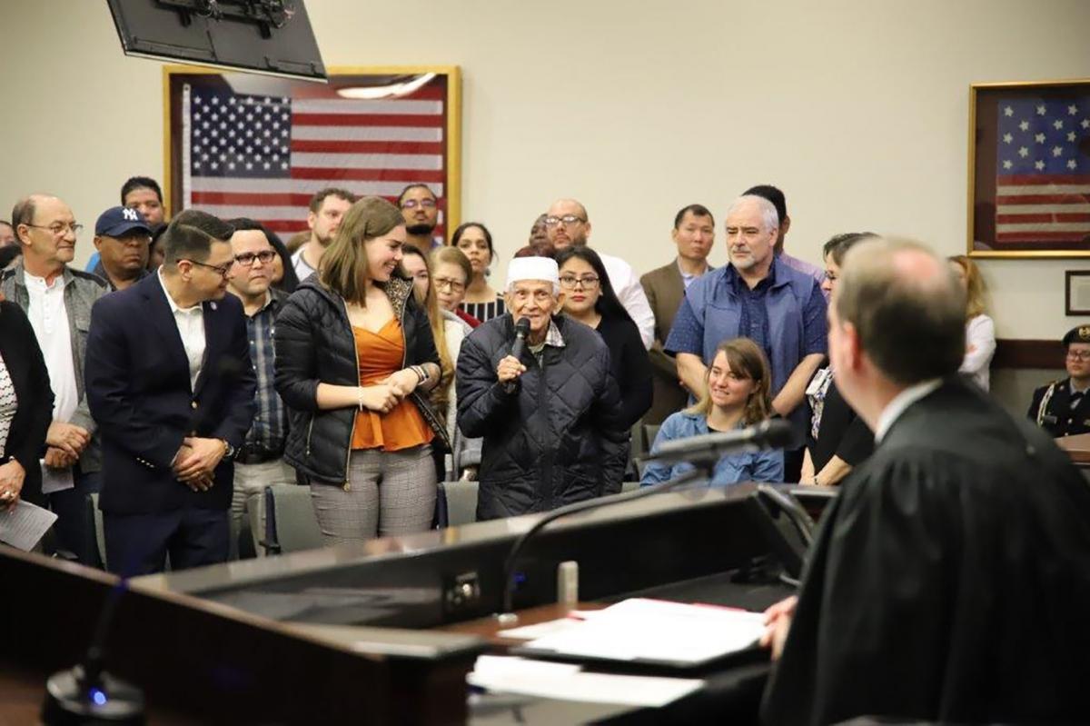 The oldest new United States citizen from Iraq introduces himself to Judge Corrigan; standing to his left and looking on in admiration is the youngest new United States citizen from Ukraine. The oldest new United States citizen from Iraq introduces himself to Judge Corrigan; standing to his left and looking on in admiration is the youngest new United States citizen from Ukraine.
